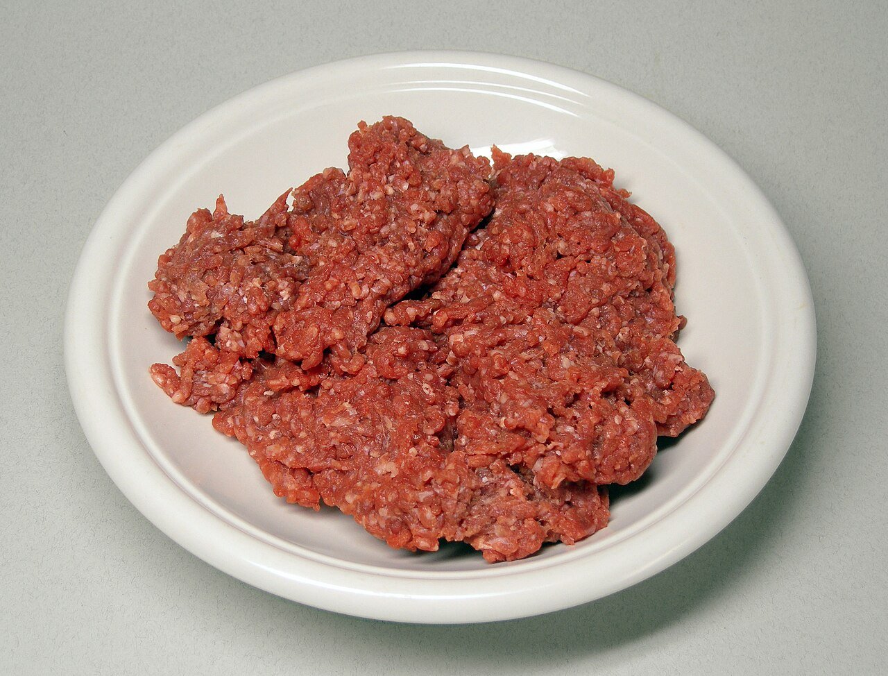 Raw ground beef in a pile before shaping into patties